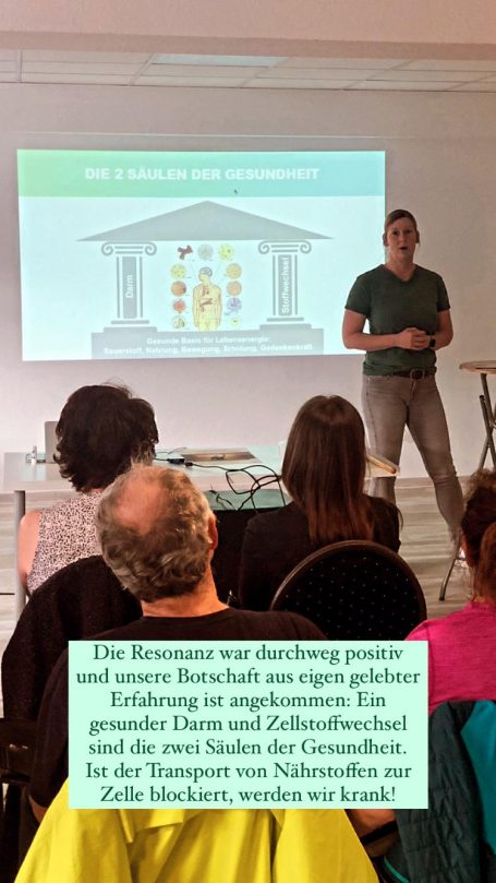 Drei Säulen der Gesundheit Vortrag Alexandra Thiery steht vor Leinwand und erklärt einem großen Publikum die drei Säulen der Gesundheit: Darm, Leber und Zellstoffwechsel.